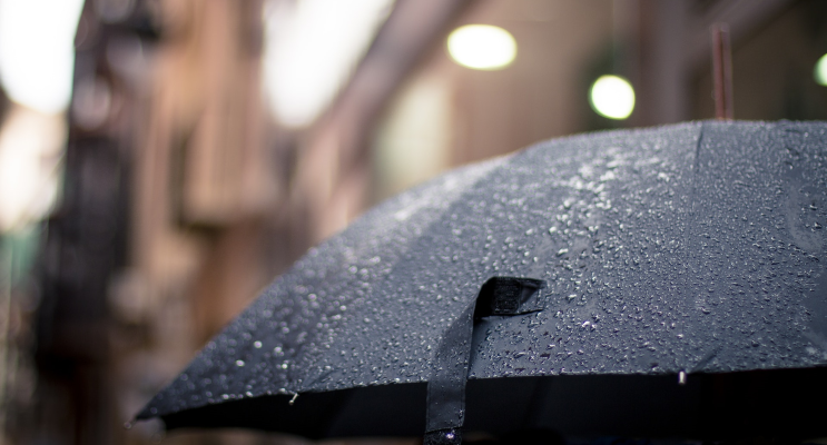 Image of a black umbrella on a street in a NJ city. This is showing that you can still find fun fast by searching for rainy day activities