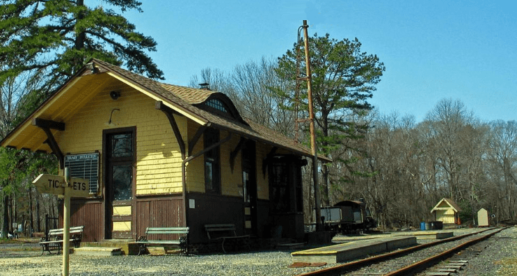 Image of a small yellow and brown outdoor ticket booth in an old train station in NJ